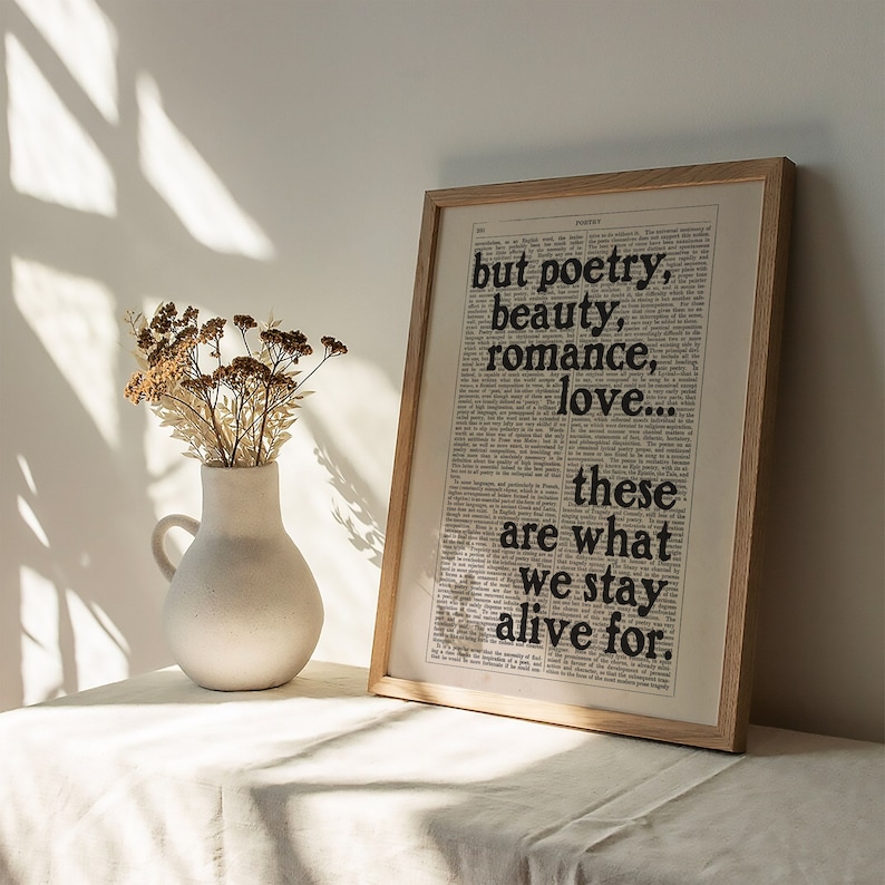 May include: A framed print with a white background and black text that reads "but poetry, beauty, romance, love... these are what we stay alive for."