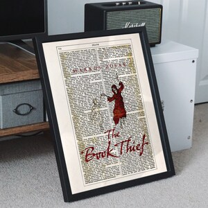 Pode incluir: Uma p&aacute;gina de livro vintage com uma ilustra&ccedil;&atilde;o vermelha da Morte, uma figura esquel&eacute;tica em uma t&uacute;nica com capuz, segurando uma foice. O texto "The Book Thief" est&aacute; impresso em vermelho na parte inferior da p&aacute;gina.