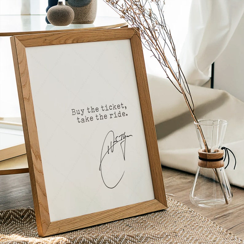 K&ouml;nnte beinhalten: Ein Holzrahmen mit dem Text "Buy the ticket, take the ride." und einer handschriftlichen Unterschrift.