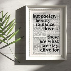 May include: A framed print with a black and white background featuring a quote from a book about poetry. The quote reads "but poetry, beauty, romance, love... these are what we stay alive for."