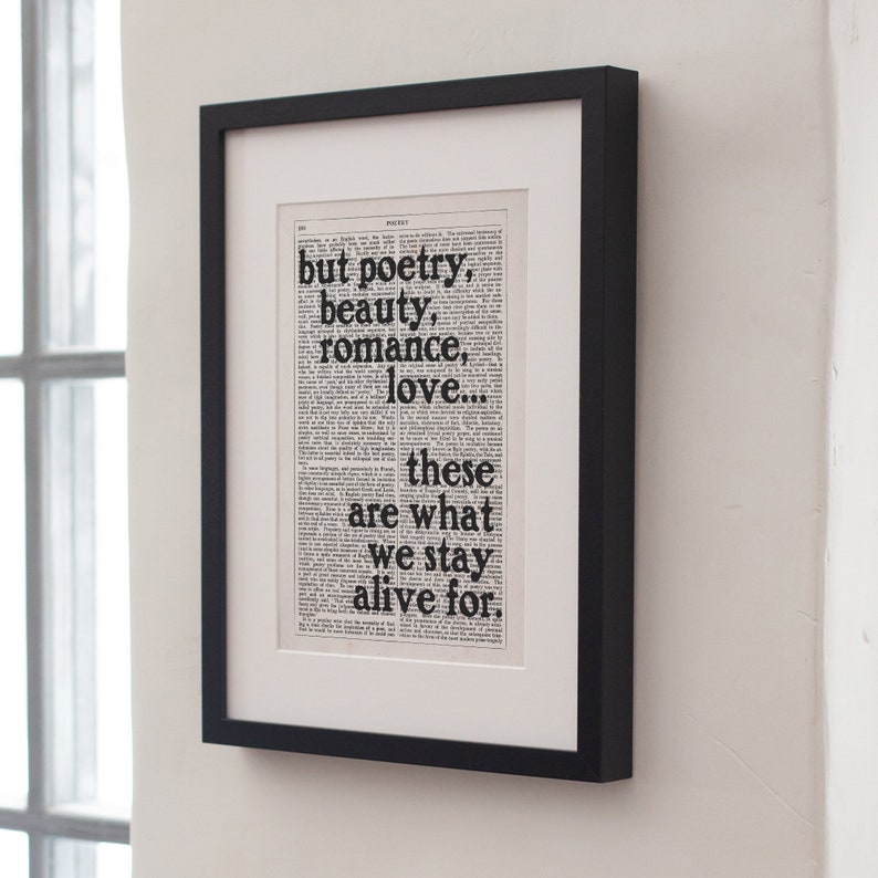 May include: A black framed print with a white background and black text. The text reads "but poetry, beauty, romance, love... these are what we stay alive for."