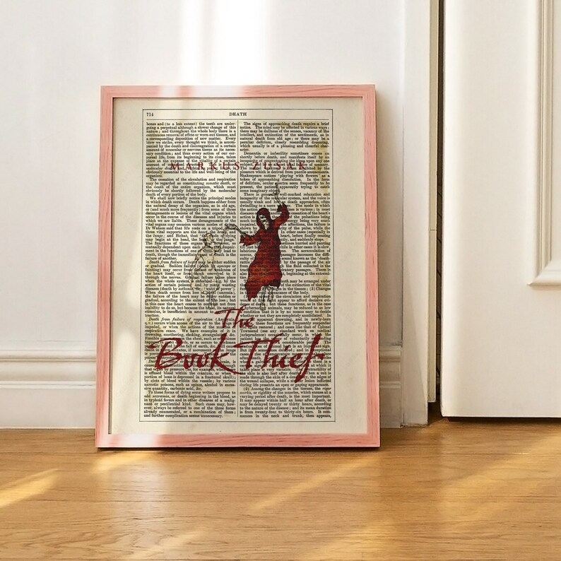 Pode incluir: Uma impress&atilde;o emoldurada de uma capa de livro com o t&iacute;tulo "The Book Thief" em letras vermelhas e pretas. O fundo &eacute; uma p&aacute;gina de dicion&aacute;rio vintage com a palavra "Death" no topo.