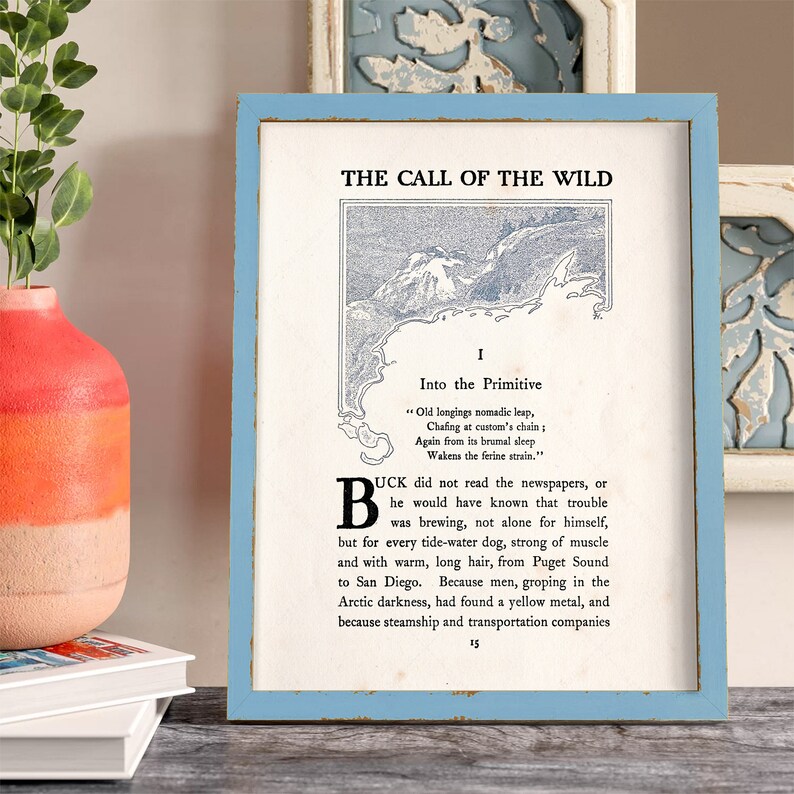 May include: A framed print of a vintage book page with the title "The Call of the Wild" and an excerpt from the book. The print is on a white background with blue text and a black and white illustration of a mountain range.