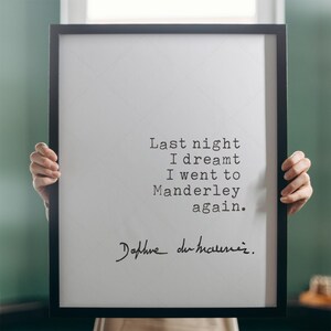 Może przedstawiać: Czarny obraz w ramie z białym tłem i czarnym tekstem, kt&oacute;ry brzmi "Last night I dreamt I went to Manderley again." Tekst jest w czcionce do maszyn do pisania. Podpis "Daphne du Maurier" jest napisany czarnym atramentem pod tekstem.