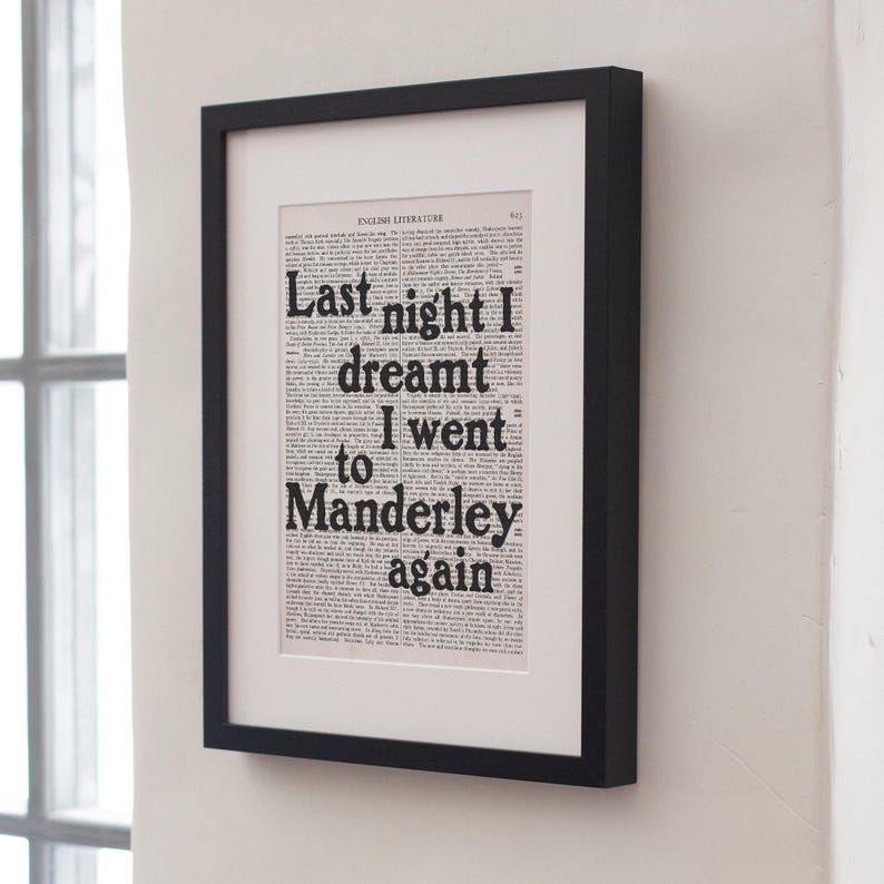 May include: A black framed print with the text "Last night I dreamt I went to Manderley again" printed on a white background. The text is in a bold, black font.