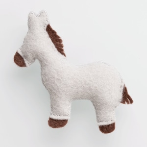 May include: A white felt horse toy with brown felt mane and tail. The horse has a stitched face and hooves.