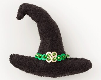 May include: A black felt witch hat with a green and gold sequin trim.