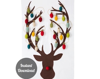 May include: White fabric Christmas advent calendar with a brown felt reindeer design. The reindeer antlers are adorned with colorful felt light bulbs. The calendar has 24 numbered pockets for treats. The words "Instant Download" are in a gray circle.