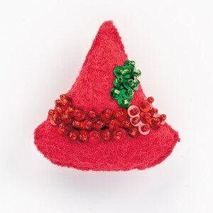 May include: A red felt cone-shaped ornament with red and green sequins. The ornament is decorated with a cluster of green sequins at the top.