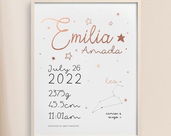 May include: A framed birth announcement with the name "Emilia Amada" in copper-colored script, along with birth details: July 26, 2022, 2375g, 45.5cm, and 11:01 am. The design includes star accents and a Leo constellation illustration.