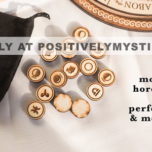 May include: Wooden moon phase and zodiac rune set with a black velvet pouch. The runes are engraved with symbols for each moon phase and zodiac sign. The text "SOLD ONLY AT POSITIVELYMYSTIC ON ETSY" is visible in the image.