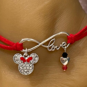 May include: Red and silver infinity bracelet with a charm that says "love" and a Minnie Mouse charm.