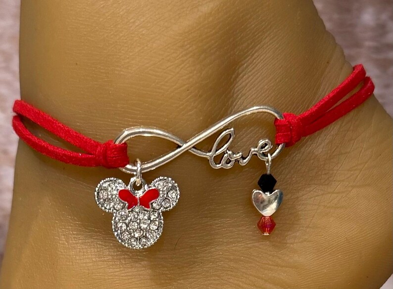May include: Red and silver infinity bracelet with a charm that says "love" and a Minnie Mouse charm.