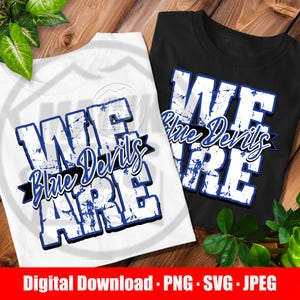 May include: A white t-shirt and a black t-shirt, each featuring a graphic design with the distressed white text WE ARE and the blue script text Blue Devils layered over a black ribbon banner. The designs are identical on both shirts.