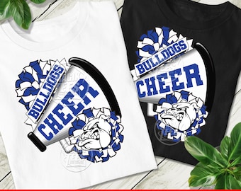 Può includere: Una t-shirt bianca e una t-shirt nera, entrambe con un design grafico raffigurante un megafono con la scritta BULLDOGS CHEER, accompagnato da pon-pon blu e bianchi e dall'illustrazione di un bulldog centrata sul davanti della maglietta.