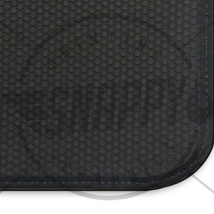Puede incluir: Primer plano de una alfombra de goma negra con un patr&oacute;n hexagonal. La alfombra tiene un borde cosido.