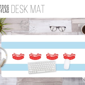 May include: A desk mat featuring the Chicago flag with four red hot dogs on the white stripes. The text "HOTDOG CHI-FLAG DESK MAT" is at the top of the image.