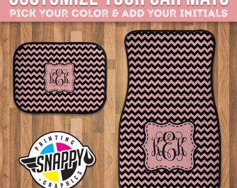 May include: Two pink and black chevron car floor mats with black stitching. The larger mat has a monogrammed initial "K.E.K." in a black frame. The smaller mat has the same monogram in a smaller frame. The mats are on a wood floor. The text "Customize Your Car Mats" and "Pick Your Color & Add Your Initials" is at the top of the image. The text "Snappy Printing Graphics" is in a circle with a paint drop.