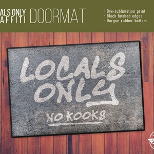 May include: A gray doormat with white graffiti-style text that reads "Locals Only No Kooks". The doormat has black edges and a brown wooden background.