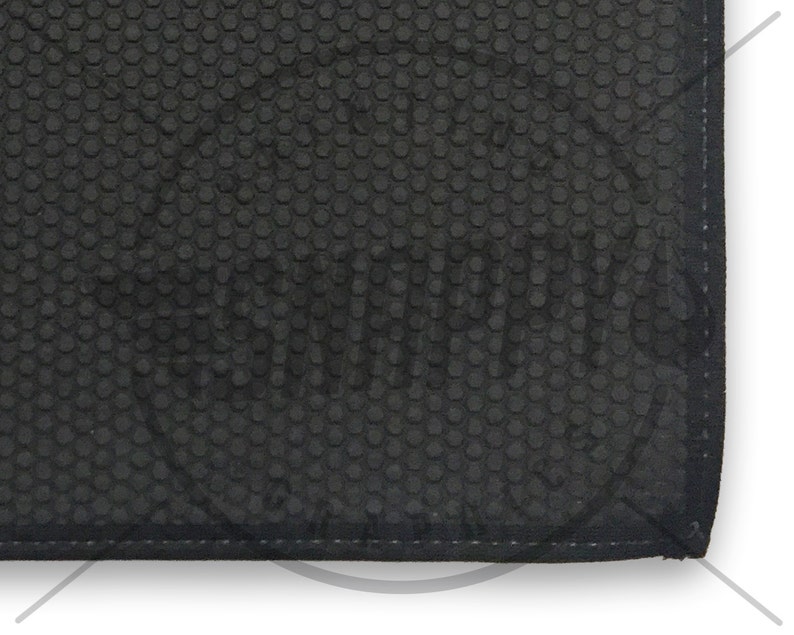 May include: Black rubber mat with a hexagonal pattern. The mat has a stitched edge.
