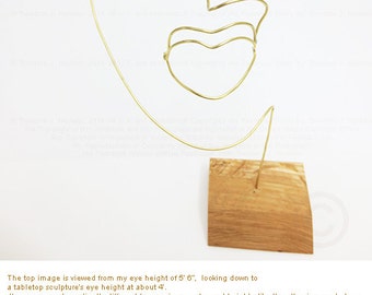 Metal art wire face sculpture. 5.5" width x 11" height x 4" in depth on wood base. Medium: 14 gauge round bare Brass wire.