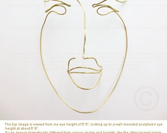 Metal wire wall sculpture of a man's face 6" width x 9.4" height x 2.5" in depth. Medium: 14 gauge Brass wire. © Theo J Huckins