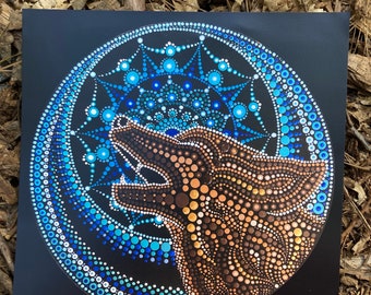 May include: A black canvas with a blue and brown mandala design. The mandala features a wolf howling at the moon, surrounded by a circle of blue and white dots.