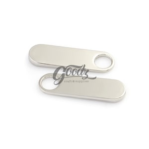 May include: Two silver-colored bottle openers with a rounded rectangular shape and a circular hole at one end. The openers are made of a shiny, reflective metal. The text "Goodz craft & supplies" is in the center.