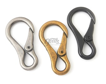 May include: Three metal swivel hooks in silver, gold, and black. The hooks are in the shape of a rounded 'S' and have a spring-loaded gate.