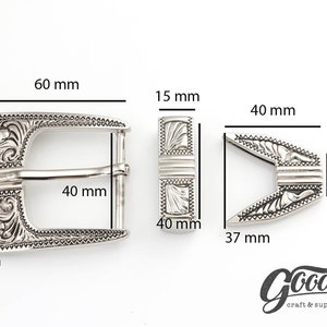 May include: Silver-toned metal belt buckle with an ornate design. The buckle measures 2.36 inches wide and 2.36 inches tall. The buckle is designed to fit a 1.57 inch wide belt.