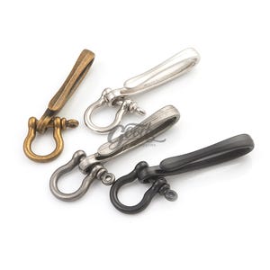 Puede incluir: Cuatro piezas de hardware para llaveros de metal en bronce, plata, metal de cañón y negro. Cada una tiene un anillo en D y un cierre giratorio. El hardware está diseñado para sujetarse a llaveros, bolsos u otros accesorios.