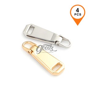 May include: A set of four metal zipper pulls featuring two silver-toned and two gold-toned pieces. Each pull has a rectangular body with a rounded end and a small loop for attachment. An orange graphic in the corner displays the text 4 PCS.