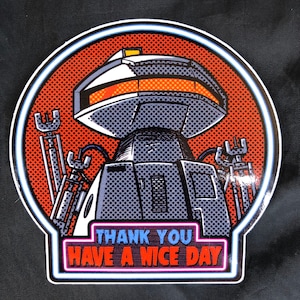 May include: A round sticker with a robot in the center. The robot is gray and has a white top with a yellow light. The robot is surrounded by a red and white dotted background. The sticker has a neon pink and blue border with the text "Thank You Have A Nice Day".