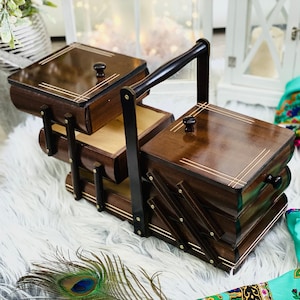 Big Wooden sewing box, dark brown concentrina storage box, cantilevered wooden accordion box with bright carved lines on lids