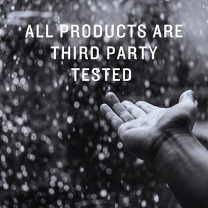 Pu&ograve; includere: Un'immagine in bianco e nero di una mano che si alza verso uno sfondo sfocato di gocce di pioggia. Il testo "ALL PRODUCTS ARE THIRD PARTY TESTED" &egrave; sovrapposto all'immagine.