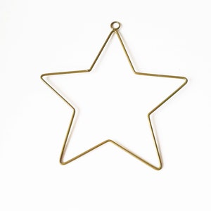 May include: A gold metal star-shaped ornament with a loop at the top for hanging.