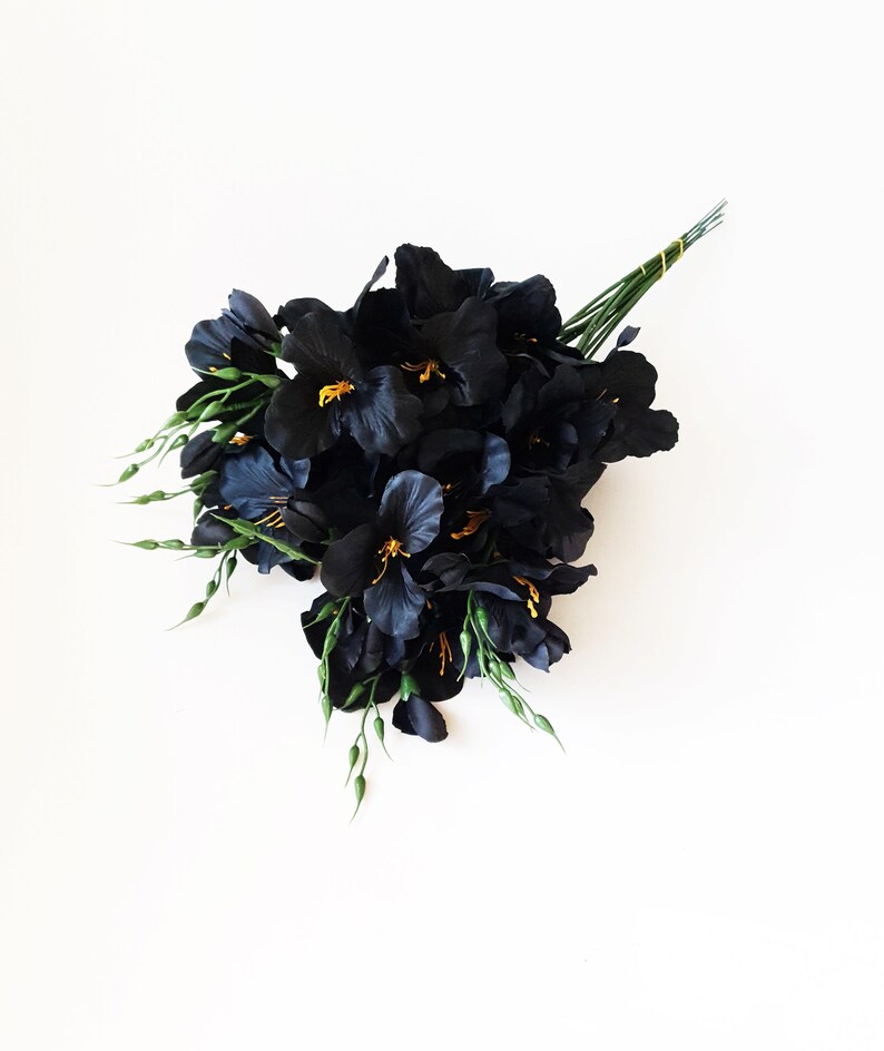 May include: A bouquet of black silk flowers with green stems and yellow centers. The flowers are arranged in a loose, natural style.