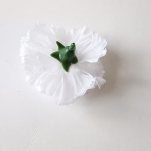 May include: A single white carnation flower with a green center. The flower is isolated on a white background.