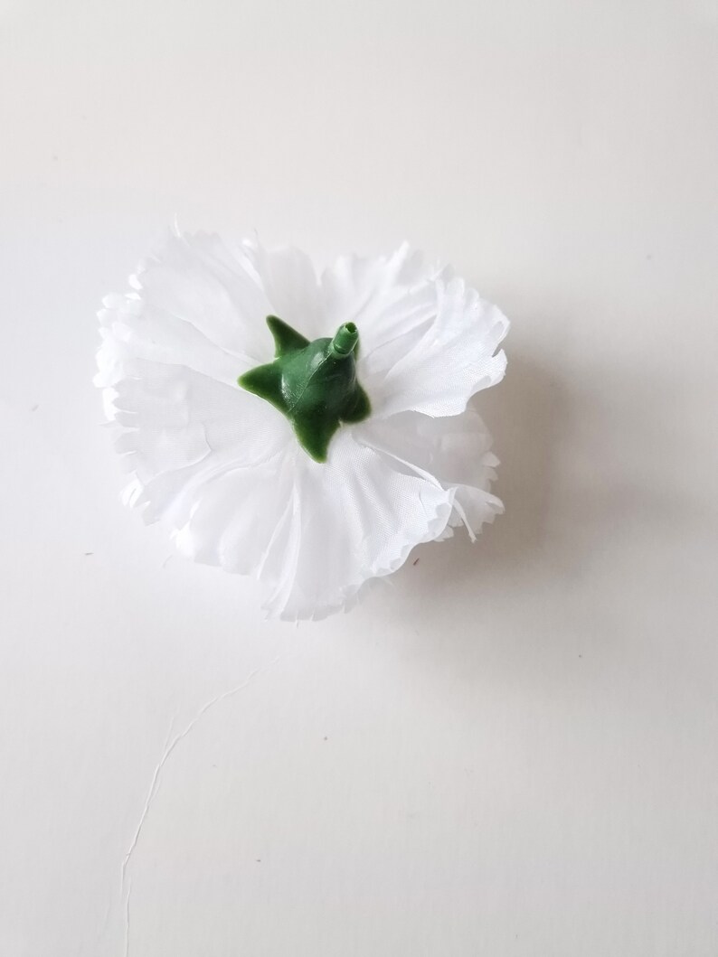 May include: A single white carnation flower with a green center. The flower is isolated on a white background.