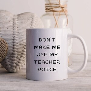 Puede incluir: Taza de caf&eacute; de cer&aacute;mica blanca con texto negro que dice "No me hagas usar mi voz de maestro".
