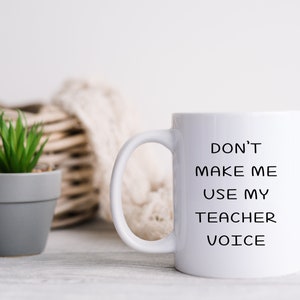 Puede incluir: Taza de cer&aacute;mica blanca con texto negro que dice "No me hagas usar mi voz de maestro".