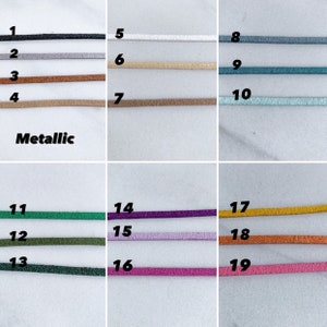 K&ouml;nnte beinhalten: Eine Sammlung von neunzehn metallischen Kordeln in verschiedenen Farben, darunter Schwarz, Silber, Bronze, Gold, T&uuml;rkis und Lila. Das Wort "Metallic" ist in Schwarz gedruckt. Diese Kordeln eignen sich f&uuml;r die Schmuckherstellung und Bastelarbeiten.