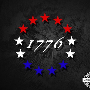 May include: A black and white graphic design with a circle of red, white, and blue stars. The year 1776 is written in white in the center of the circle. The words "Made in USA" are written in a circle with stars around the words.