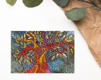 May include: Colorful tree art print with a vibrant design. The tree features a trunk with yellow, orange, and purple hues, adorned with green leaves and red branches. The background is a dark blue with small white dots.