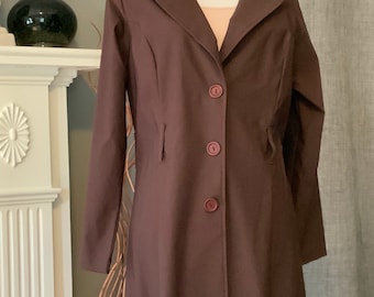 May include: A long brown coat with a collar and five buttons down the front.
