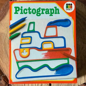 May include: A vintage Pictograph drawing set with a colorful boat design. The box is orange with the word "Pictograph" in green. Includes blue, yellow, and green crayons. The boat design is outlined in green, blue, yellow, and red.