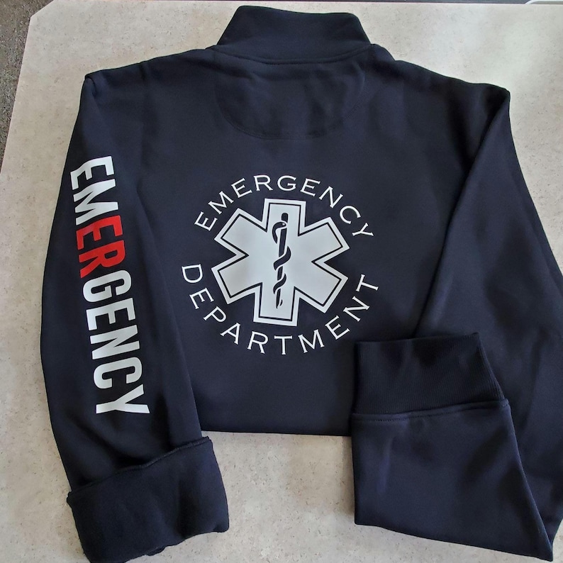 May include: Black zippered jacket with the words "EMERGENCY DEPARTMENT" in white on the back and the word "EMERGENCY" in white with a red "E" on the left sleeve.