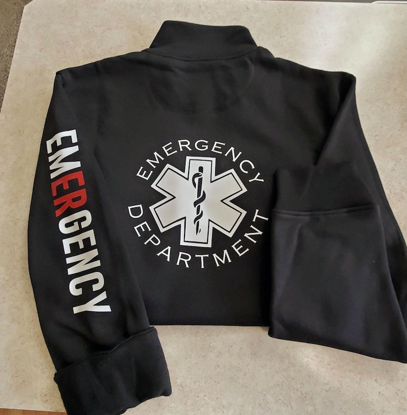 May include: Black zippered jacket with the words "EMERGENCY DEPARTMENT" in white lettering and a white star of life symbol on the back. The words "EMERGENCY" are printed in red on the left sleeve.