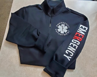 May include: Black quarter-zip pullover sweatshirt with a white "Emergency Department" logo featuring a medical star of life on the left chest and the word "Emergency" in white and red on the right sleeve.