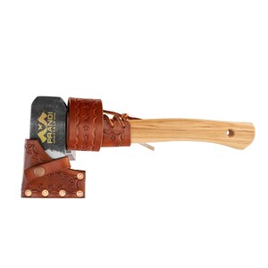 May include: A small axe with a brown leather sheath and a wooden handle. The axe head has a gold logo that says "PRANDI" with a stylized mountain design.